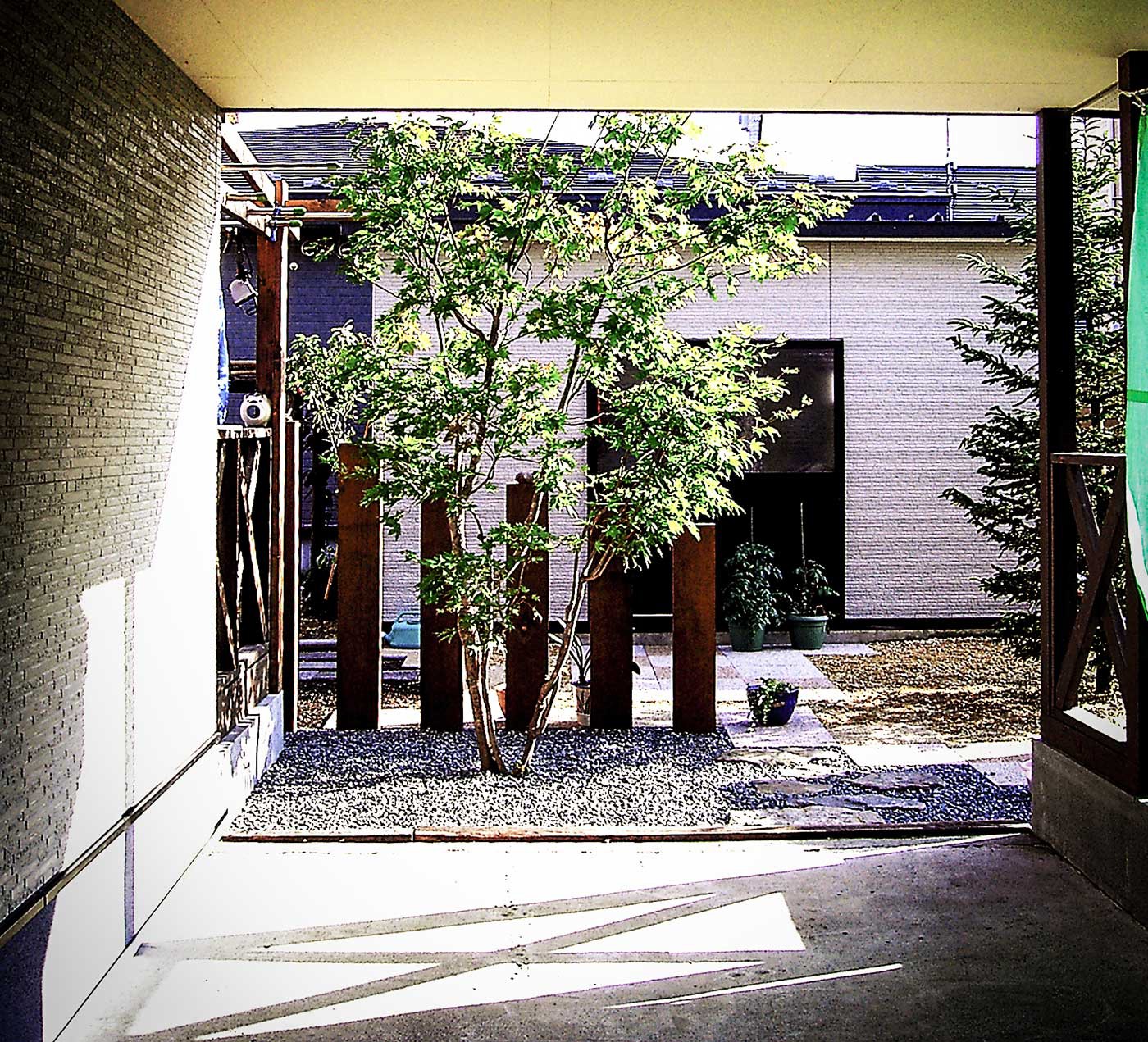 カーポート越しに見る庭園のエントランス