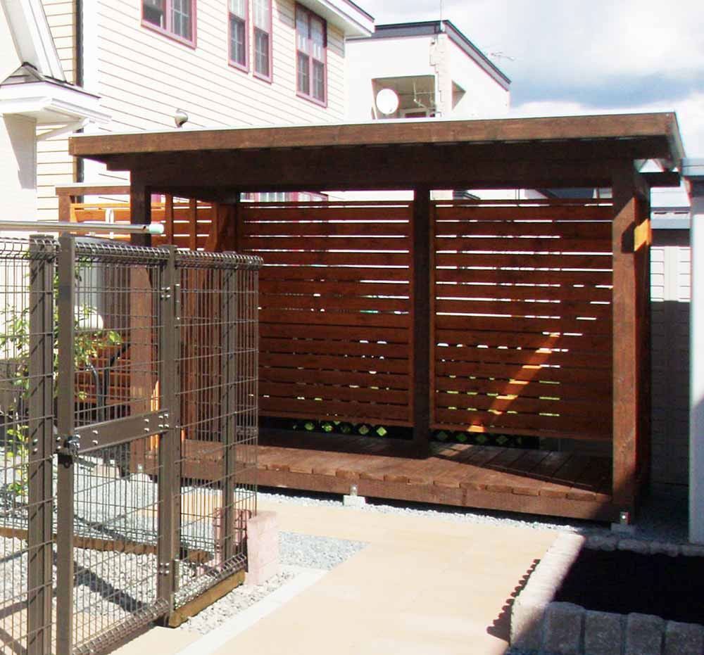 背面にフェンスを共用した薪小屋のカタチ。